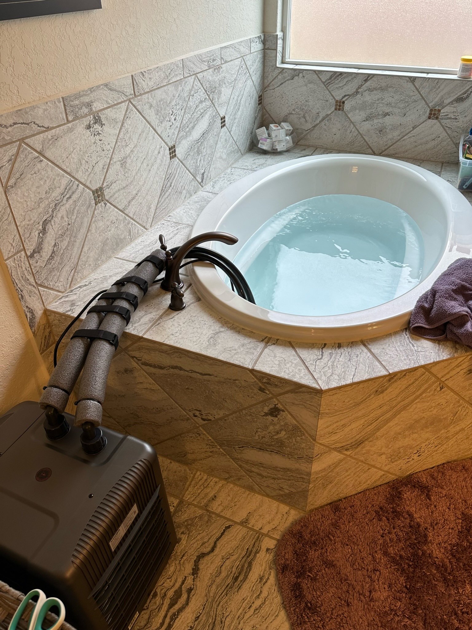 Insulated hoses connecting a water chiller to the bathtub test setup, March 18, 2023.