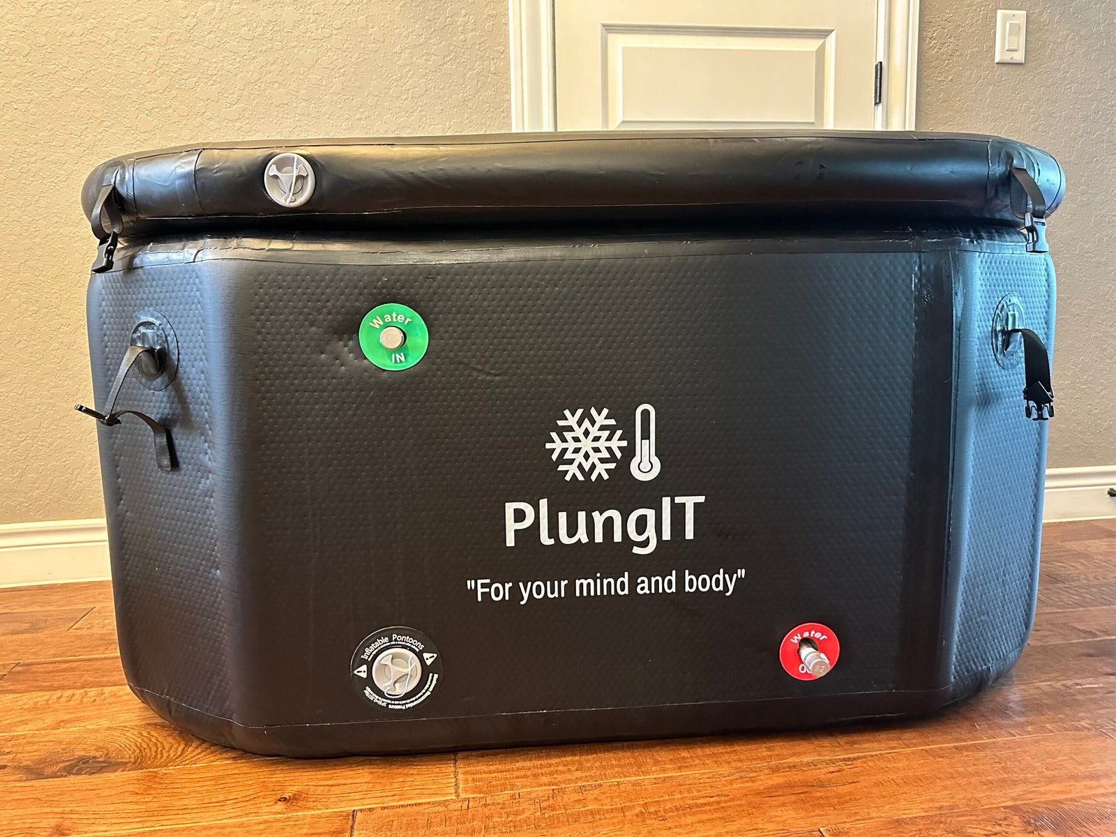 Finished branded one-person PlungIT inflatable cold-plunge tub with water inlet and outlet ports.